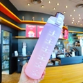 Detail of the purple-to-pink gradient frosted sports bottle with handle and scale - 1000ml / Purple Lid Gradient