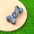 Blue and white spotted bone-shaped agate stone figurine on a wooden stand - Sodalite