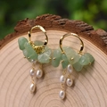 Long pearl drop earrings with green stones and gold hoops on a wood background - Green Aventurine