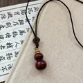 Detail showing the polished dark reddish-brown wooden double gourd pendant with a mystic knot - Red Wood Texture Gourd Pendant / Red Rope (Double Gourd Style)