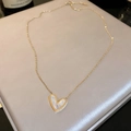 Golden heart necklace with iridescent mother-of-pearl inlay on grey silk background - Asymmetric Shell Heart Necklace