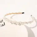 Macro detail of elegant pearl headband with gold alloy base and tiered white beads - One Large and Four Small Pearls