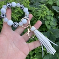 Detail of beaded keychain bracelet with leopard print beads and white leather tassel - Off White