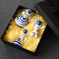 Set regalo astronauta con tre figurine in resina e stringa di luci su sfondo scuro - Set Scatola Regalo Blu Interstellare