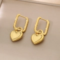 Detailed view of gold heart drop earrings with textured rectangular clasps and radial engravings - Gold
