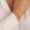 Detailed view of 18K gold plated rope chain bracelet worn on a female wrist over white shirt - 3mm Rope Bracelet