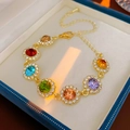 Macro detail of a gold bracelet with colorful gems and white zircon inlay in a jewelry box - Gold (HB1617)