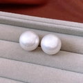 Dettaglio di perle bianche tonde lucide presentate in una scatola di velluto grigio - Medio 2cm / Bianco