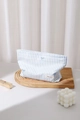 Dettaglio della borsa cosmetica a righe blu con fiocco su vassoio di legno - Grande / Righe Blu