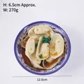 Modelo de dumpling artificial en cuenco de porcelana azul y blanca con salsa detallada - Dumplings Hervidos