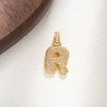 Detailed macro view of a gold-plated letter R pendant encrusted with sparkling zircons - Letter R