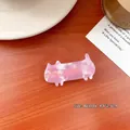 Pinza para el pelo de gato rosa jaspeado con detalles dorados sobre mesa de madera - Pinza de Gato Mármol Rosa