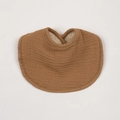 Close-up of caramel cotton muslin baby bib with absorbent layer and soft crinkle texture - Brown