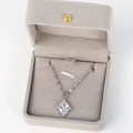 Detailed view of silver crisscross pendant with diamonds in a luxury grey jewelry box - Oval White Zircon Style 5 / Platinum