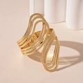 Detail van gouden meerlaagse golvende open armband met een matte metalen textuur - Gouden Meerlaagse Open Armband