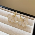 Macro view of gold flower earrings with pearly white petals in a textured velvet box - 29# Pearl White Flower Buckle (29# Ear Buckle-Gold-White)