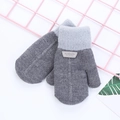 Détail de moufles en tricot gris bicolore montrant l'étiquette en cuir de mode - gris foncé