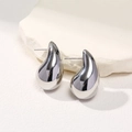 Macro shot of silver teardrop earrings with a polished metallic finish on white stones - Large Silver