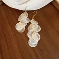 Detalle de pendientes de borla de nácar blanco con aros dorados en bandeja de madera - Gancho Dorado / Disco Blanco