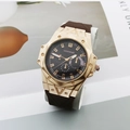 Detail of octagonal gold watch case with black dial and brown silicone strap on a desk - Rose Gold Case Coffee Dial Coffee Strap
