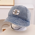 Detail van blauwe denim vissershoed met geborduurde BEST-patch en verstelbaar windkoord - 50cm (1-3 jaar) / Blauw
