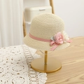 Detail of beige straw hat featuring woven pink ribbon, floral accents and lace leaves - Straw Hat / Beige