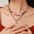 Close-up of double-layer Christmas necklace with red beads and a festive bell pendant - D1236 Double Layer Christmas Bell Pendant