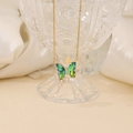 Elegante collana a farfalla dorata con cristalli verde acqua su un calice di cristallo - Verde Pavone