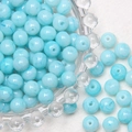 Macro shot of 8mm light blue frosted glass beads with marble texture in a glass dish - Crackle Light Blue