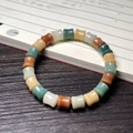 Close-up of bamboo-shaped Bodhi root beads in multiple colors on a wooden surface - Multicolor Bamboo Style