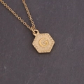 Macro detail of golden hexagonal pendant with letter G and hammered radial texture - Letter G (7#G)
