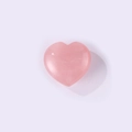 Polished pink rose quartz heart stone gemstone accessory on light purple background - Rose Quartz