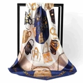 Close-up of square silk scarf featuring luxury handbag and golden chain prints - Blue