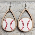 Detailansicht der hölzernen Baseball-Ohrringe in Tropfenform auf grauem Stein - Weißer Baseball