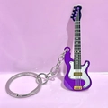 Detail of purple electric guitar keychain with metal ring on a pink background - Purple