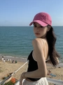 Pink distressed baseball cap with star patch shown in a sunny beach vacation setting - Rose Red