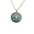 Detailed close-up of tree of life pendant with turquoise stones and golden chain - Turquoise