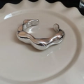 Vista dettagliata del bracciale argento irregolare con design a onde su vassoio - Bracciale Irregolare Argentato