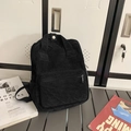 Modischer schwarzer Cord-Mini-Rucksack für Damen in einem modernen Freizeit-Studio - Schwarz