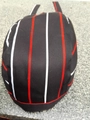 Detailed top view of a black chef hat with red and white stripes on textured stone background - Rainbow Striped