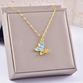 Collana a farfalla dorata con smalto celeste e zirconi scintillanti su portagioie - Stile Farfalla