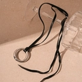 Pendentif anneau argenté sur cordon en cuir noir présenté sur un verre élégant - Collier Corde en Cuir Noir Cercle Argent