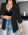 Detalle de un blazer negro de manga larga con solapas sobre un top de encaje negro - S / Negro