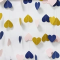 Close-up of glitter gold, navy, and pink paper heart garland on a white wall - Heart / Gold + Dark Blue + Light Pink
