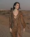 Dettaglio dell'abito leopardato con scollo a balze e maniche lunghe nella luce del deserto - S / Stampa leopardata