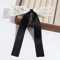 Close-up of elegant double-layered bow hair clip with white lace and long black silk ribbons - Black Lace