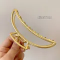 Close-up of 11cm gold minimalist hair claw clip featuring a sleek semi-moon metal design - Large Crescent Moon