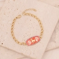 Detail of gold bracelet featuring red enamel charm with white clouds and pink zircon border - Capricorn