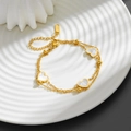 Detailansicht eines 18K vergoldeten Edelstahlarmbands mit weißen Herzmuscheln auf Keramik - N211 Herz Armband