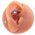 Gros plan sur un piercing industriel arc-en-ciel avec pendentif tournesol et perle blanche - Tournesol